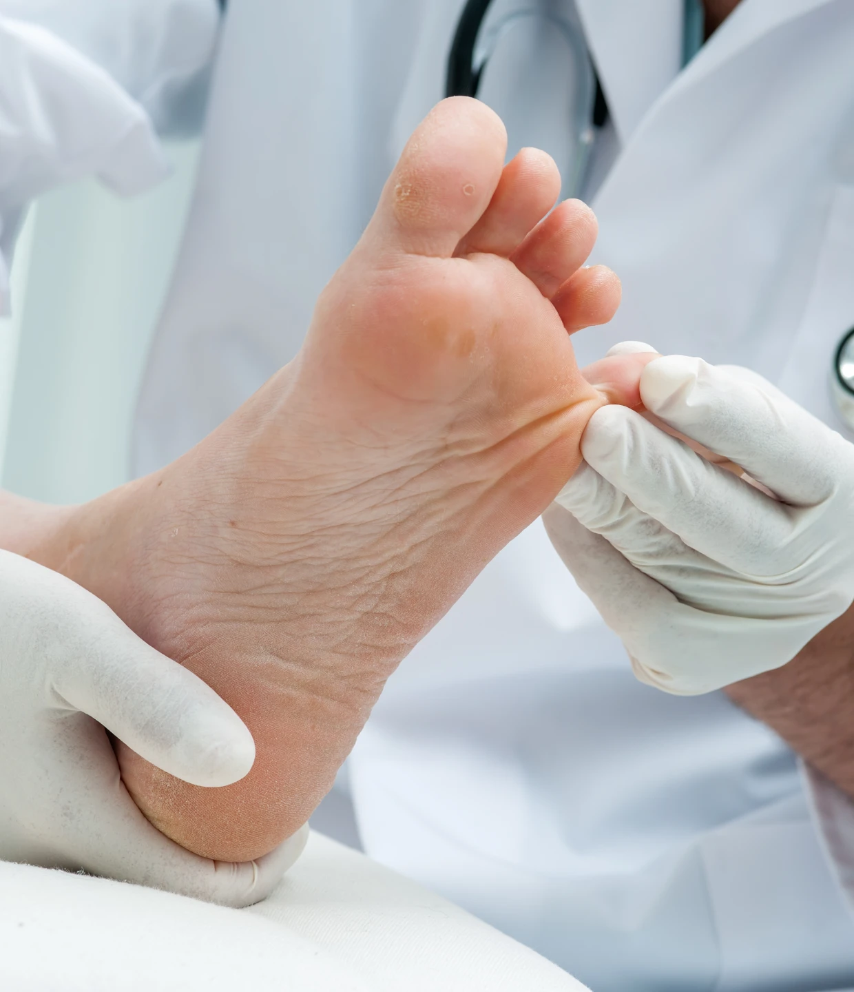 Doctor examining patient's foot with gloves.